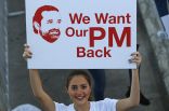 A Lebanese woman holds a placard supporting the outgoing Lebanese Prime Minister Saad Hariri to return